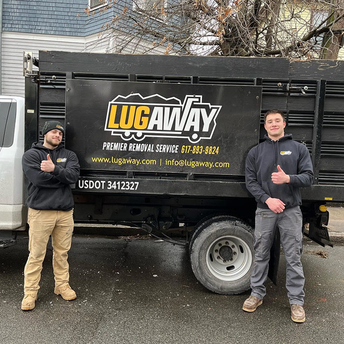 two guys standing in front of a lug away junk removal truck