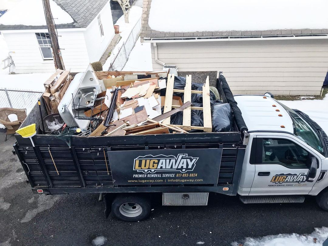 A Lug Away truck full of debris from a demolition job